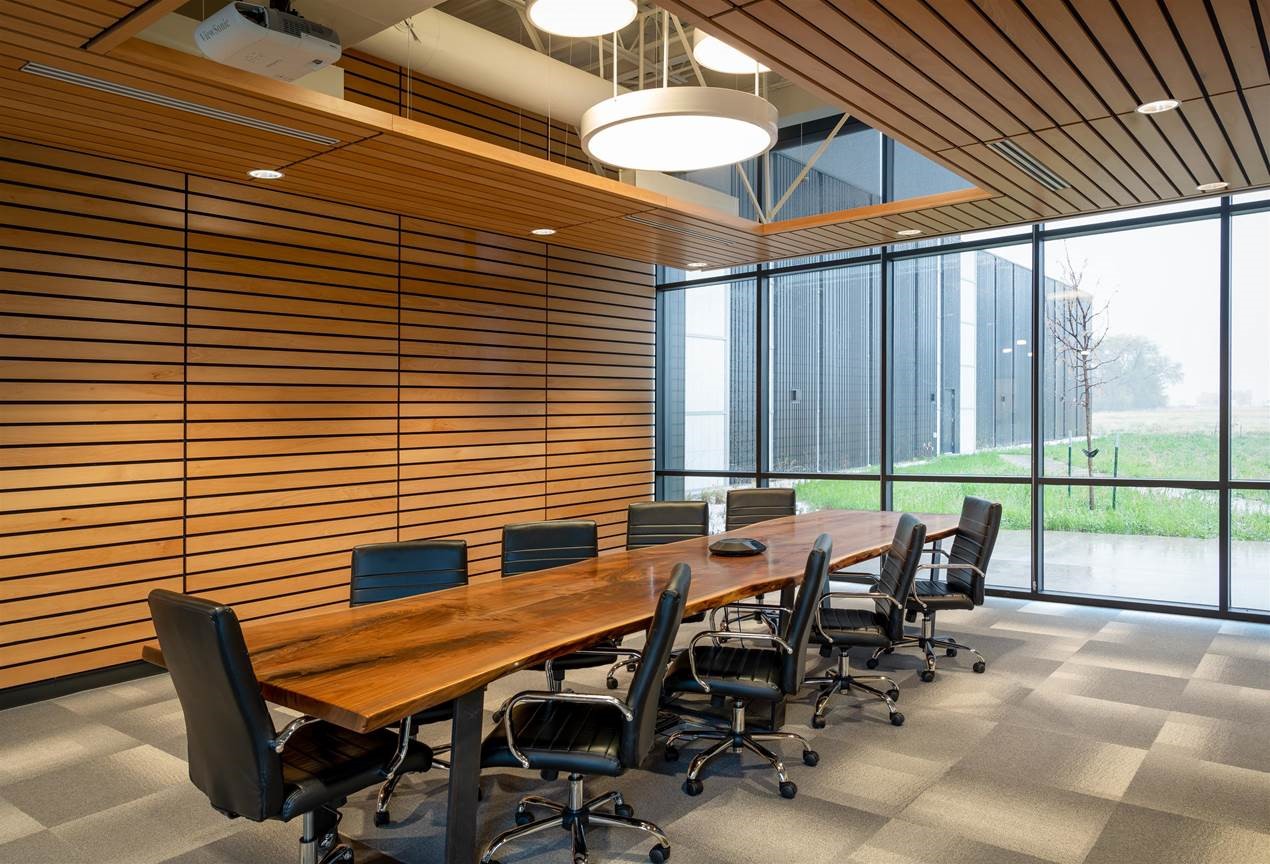ARL Conference Room Conference room space, with wood slatted walls, and a large wooden table in the middle. Chairs surround the table.