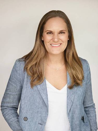 Sarah Pearson A woman with long hair wearing a gray blazer and white shirt.