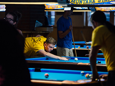 Montana State University student employee teaching billiards in the Strand Union Rec Center