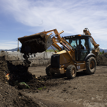 machine turning compost dirt