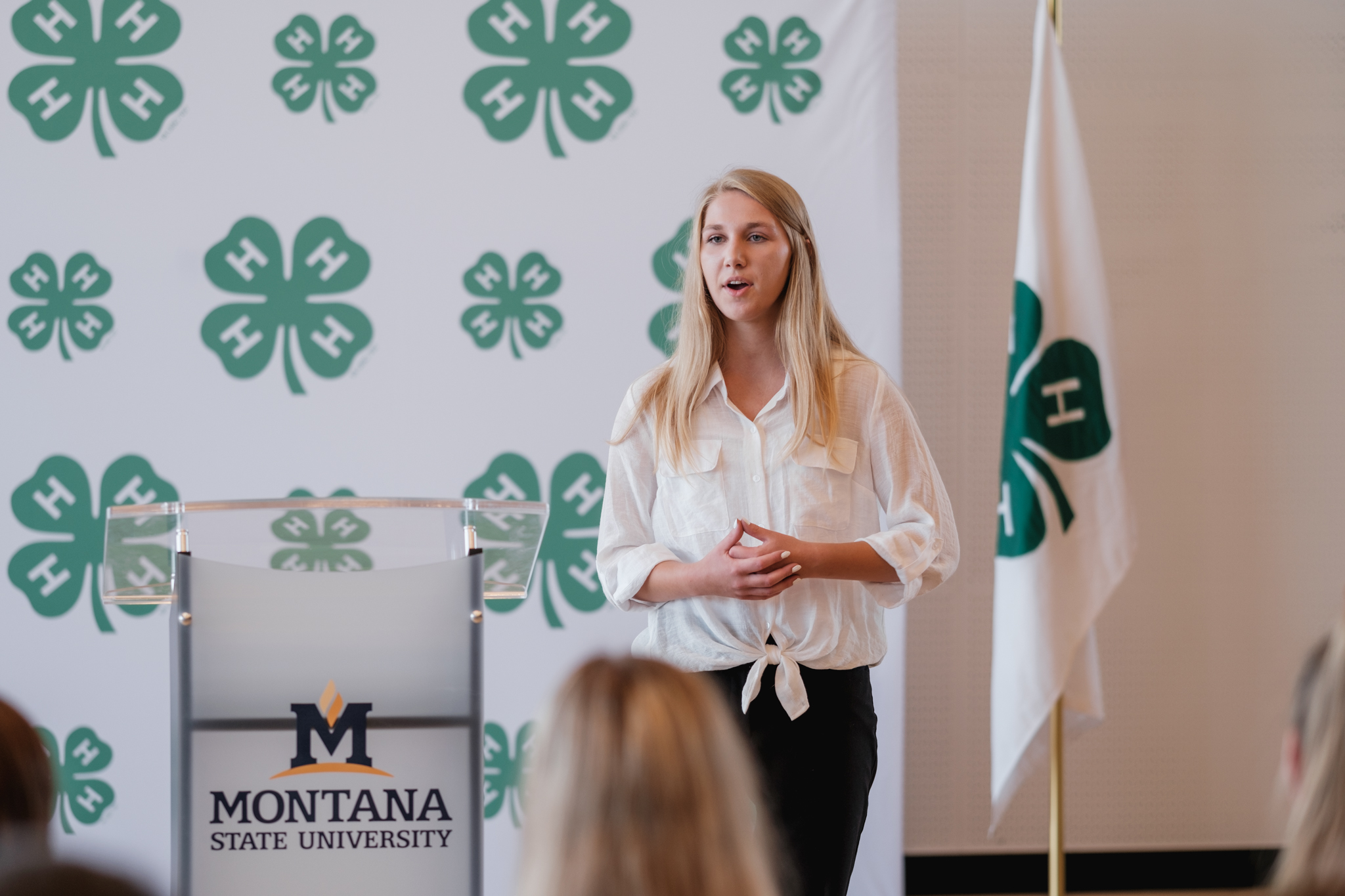 a female club member addresses a crowd