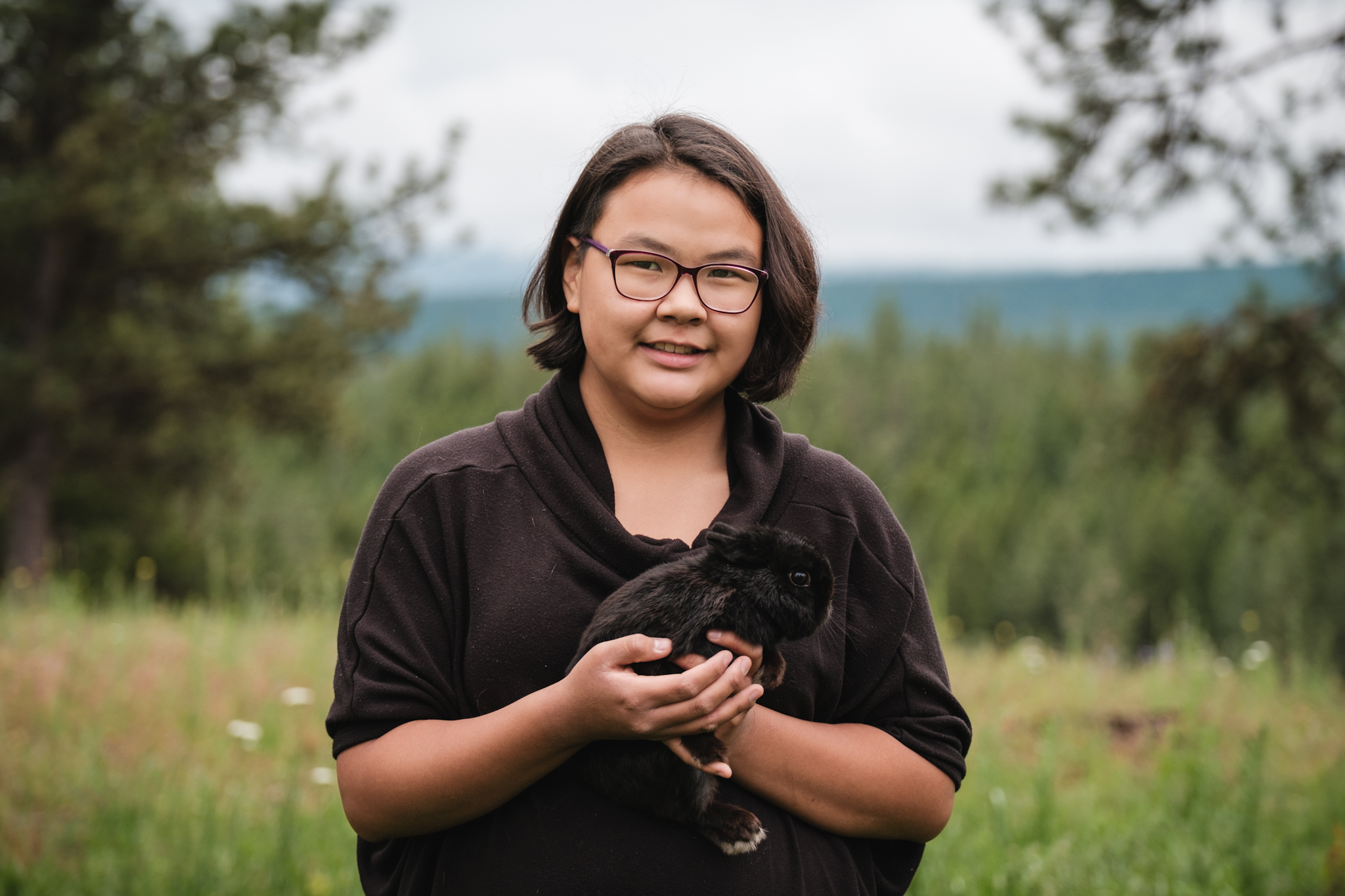 a teen boy holds his rabbit