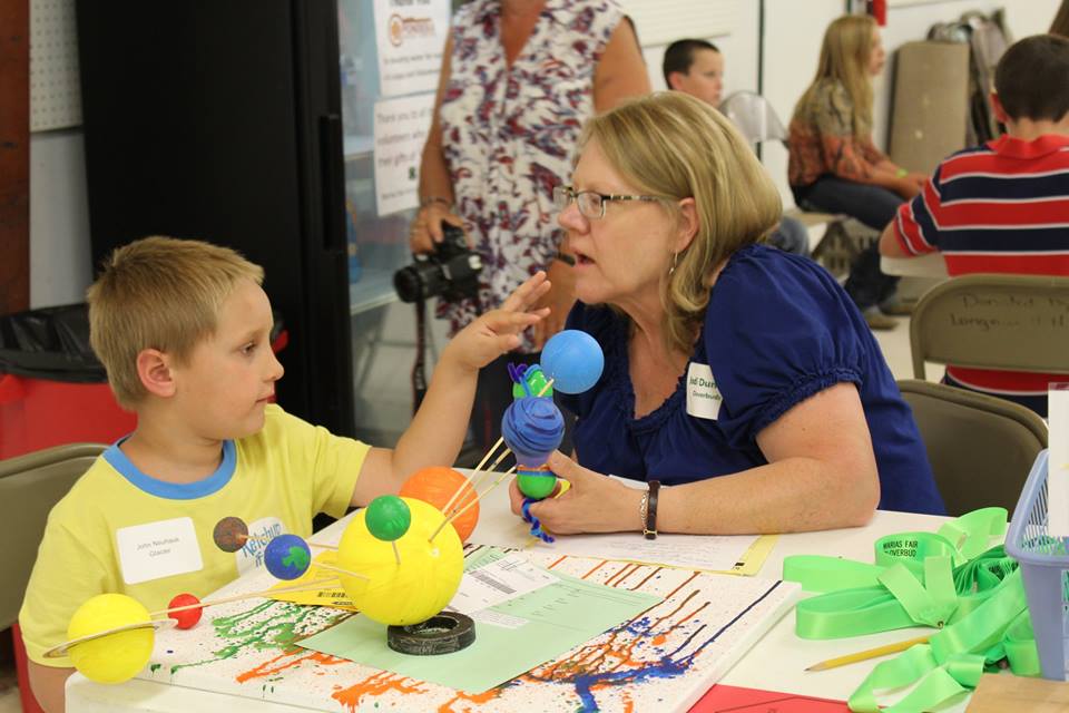 a young boy shows off his science project