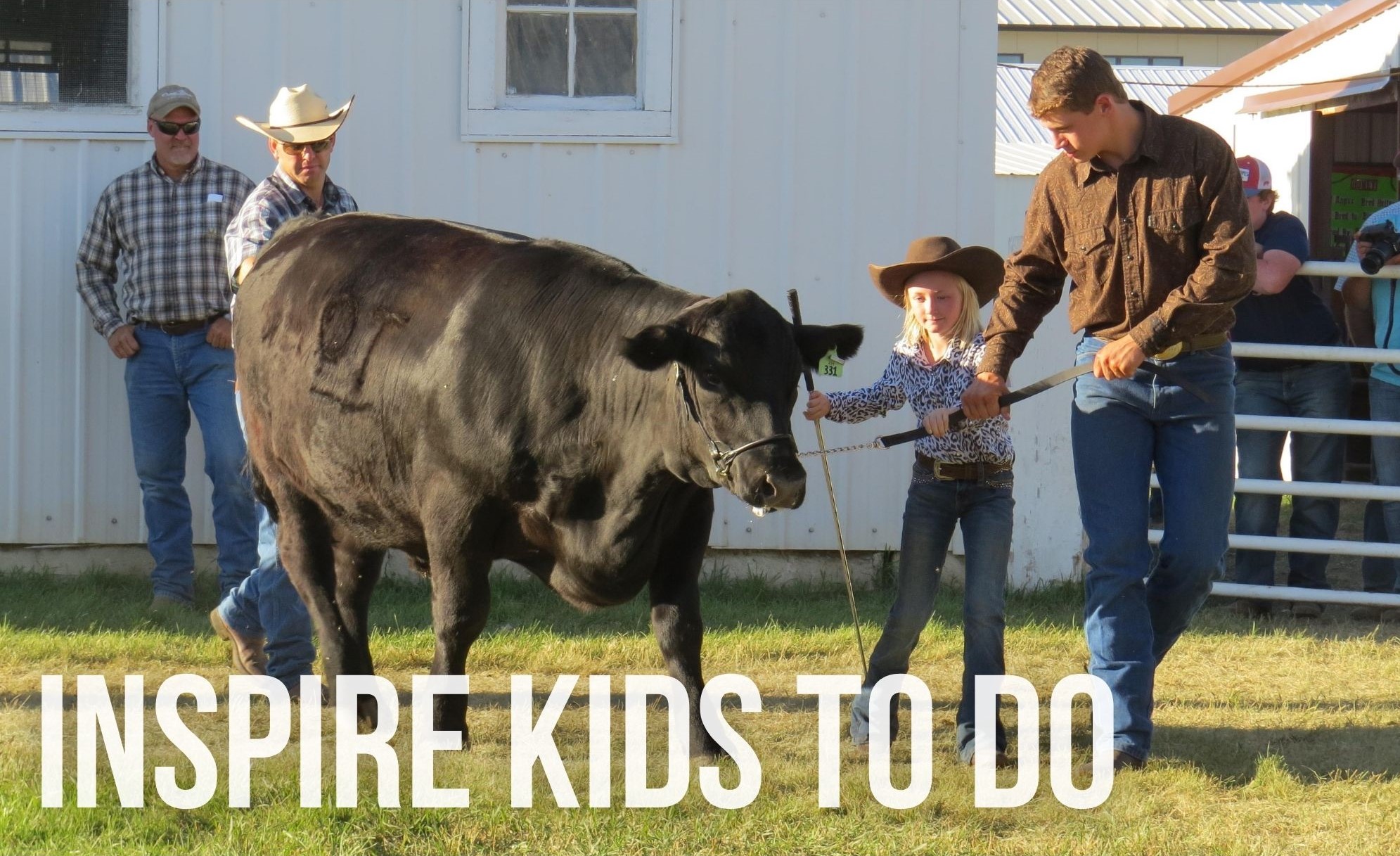 a volunteer helps a young girl with her steer