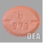 A lab image of an orange-ish red-ish pill