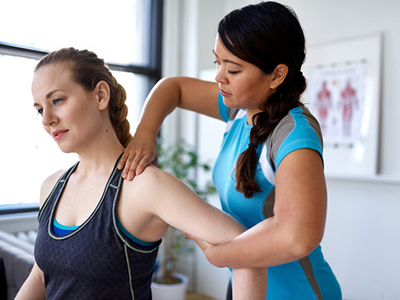 Physical Therapist Assistant Degree A female physical therapy assitant helps a patient stretch her shoulder.