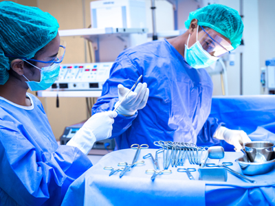 Respiratory Therapy Degree A surgical technologist stands over a tray of surgical tools as she hands a surgeon one of the implements while a patient is being operated on.