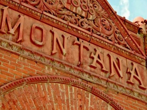 Close up of the front of a brick building with a facade that reads "Montana."
